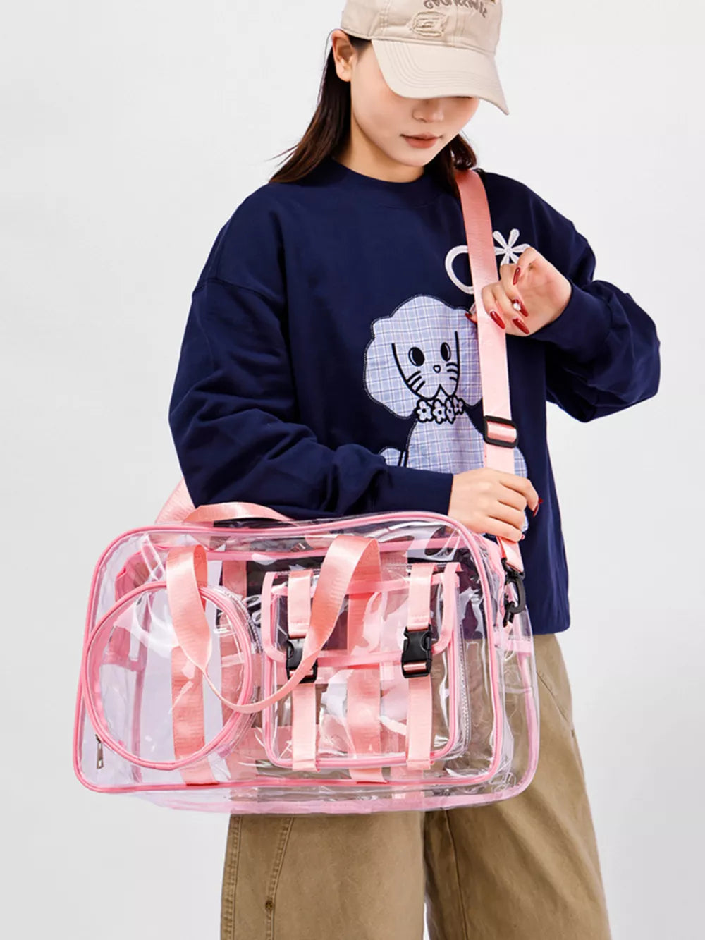 Chic clear PVC travel bag with pink accents and adjustable strap.