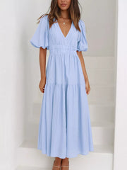 Light blue midi dress with puff sleeves, V-neck, cinched waist, and tiered skirt.