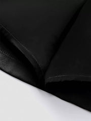 Black pleated mini skirt detail showing defined waist and fabric texture.