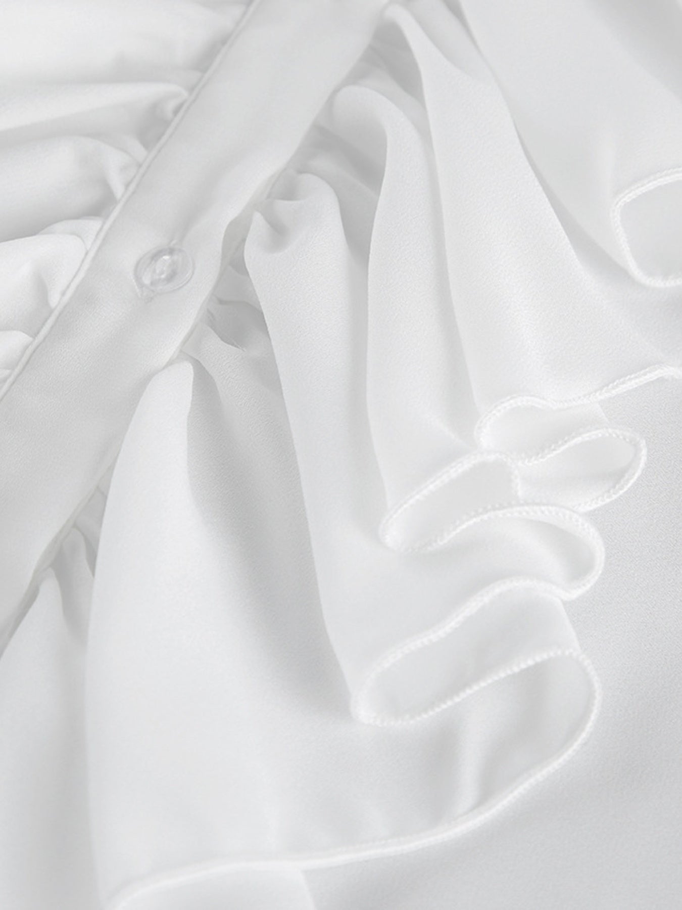 White ruffled flounce sleeve blouse with button detail and airy chiffon fabric.