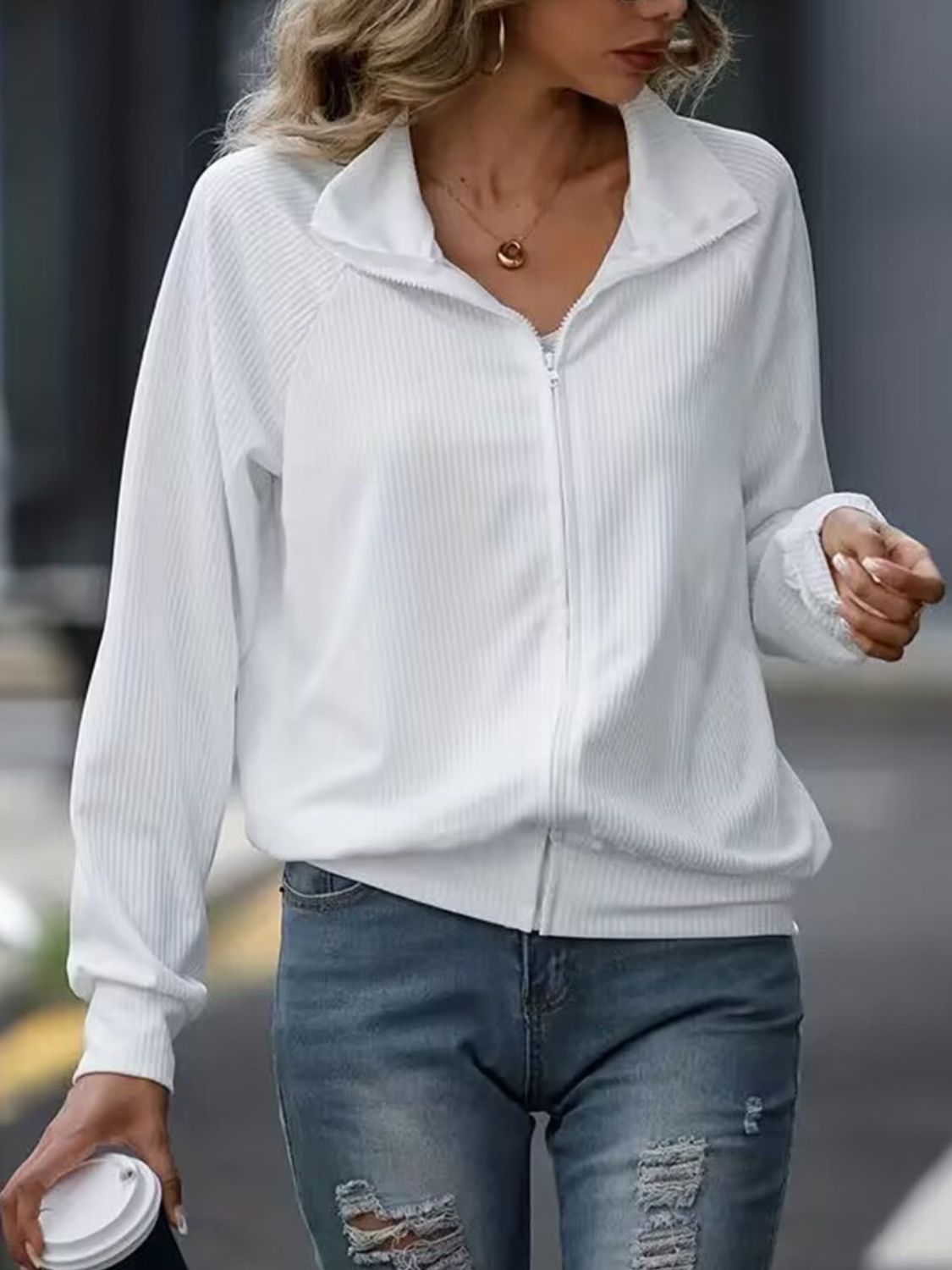White ribbed zip-up jacket with raglan sleeves and a stand-up collar.