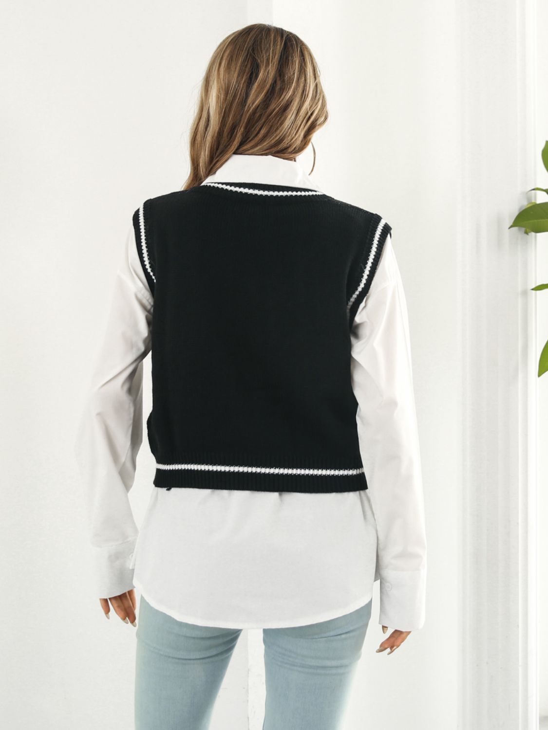 Black acrylic knit vest with white trim and argyle pattern, V-neck, sleeveless.