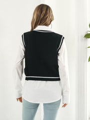 Black acrylic knit vest with white trim and argyle pattern, V-neck, sleeveless.