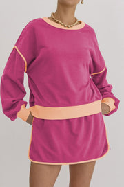Pink sweatshirt and skort set with contrast trim and peach accents.