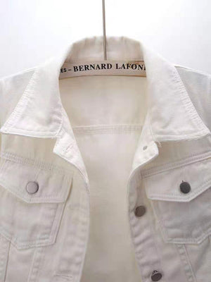 White denim trucker jacket with button-flap chest pockets and collar detail.