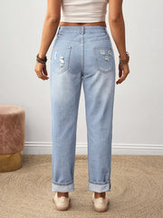 Light wash denim jeans with distressed details and cuffed hems.