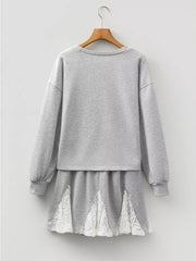Grey cotton two-piece set with crewneck sweatshirt and lace-trimmed skirt.