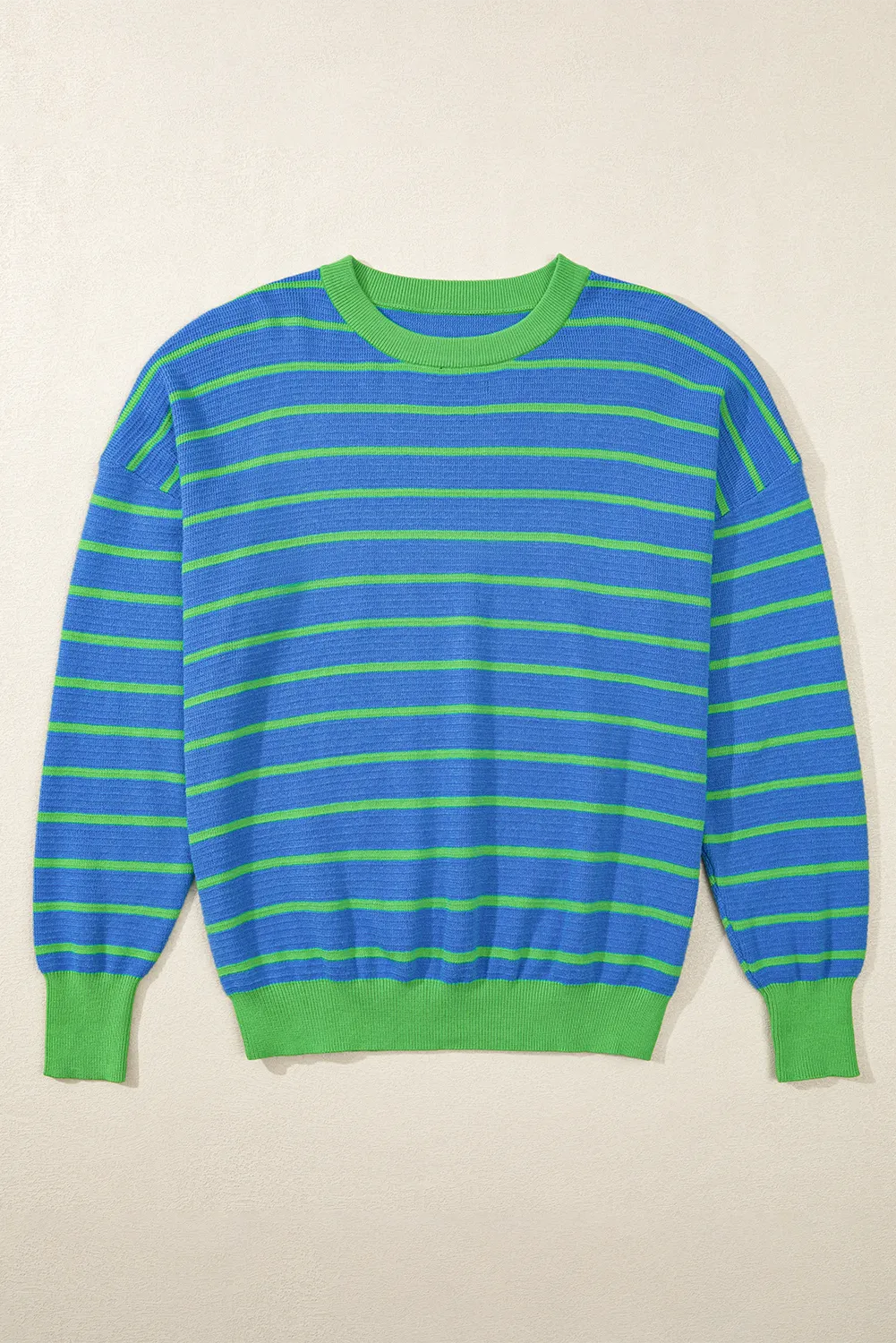 Blue waffle knit sweater with green stripes and contrasting green crew neck, cuffs, and hem.