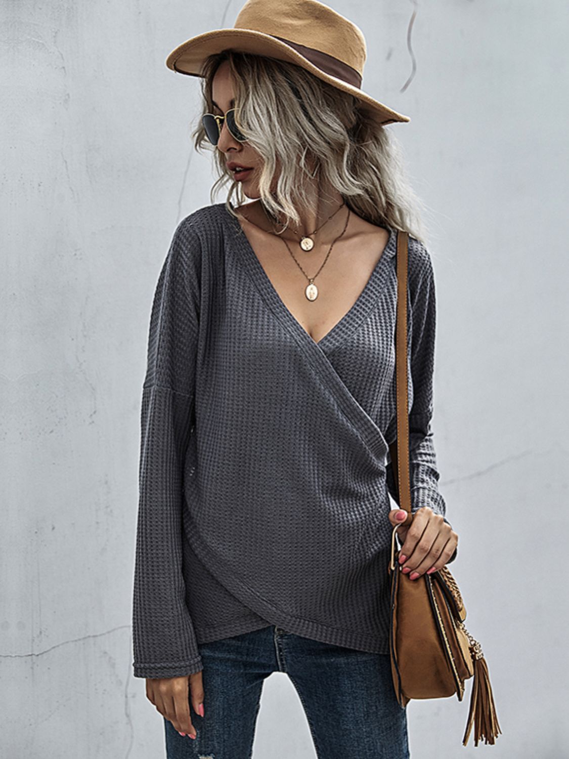 Dark gray waffle knit crossover blouse with long sleeves and a deep V-neck.
