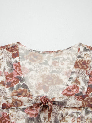 Charming floral print mesh blouse with tie detail and V-neckline.