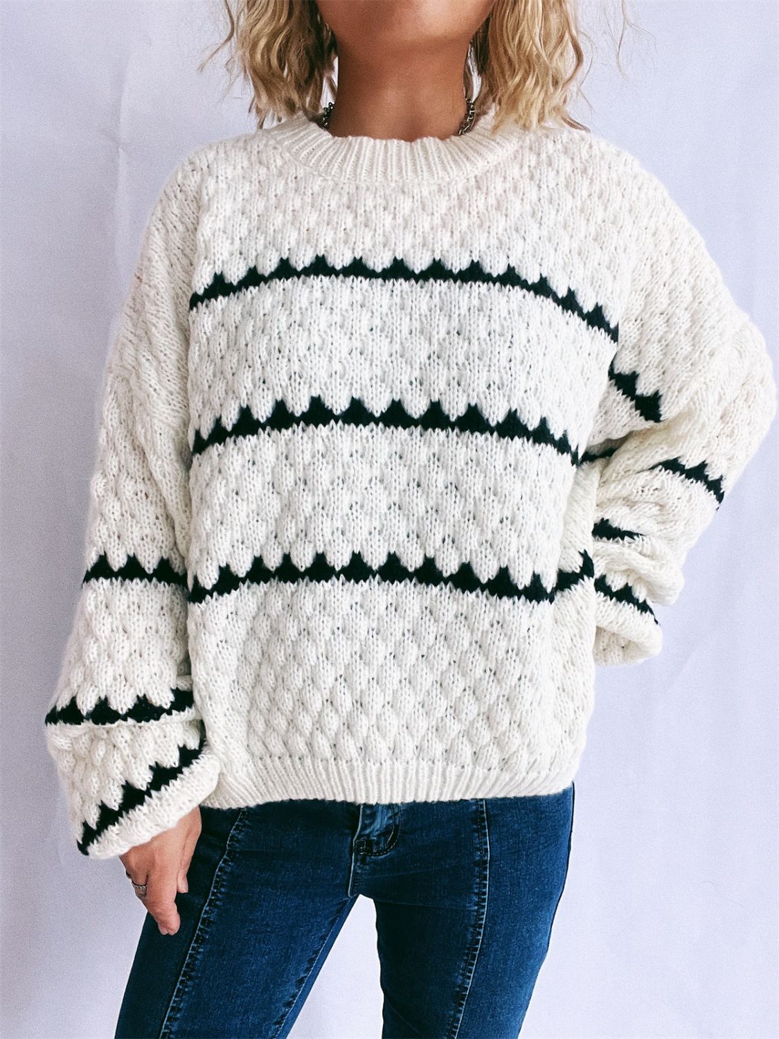 White acrylic knit jumper with black chevron stripes and textured diamond pattern.
