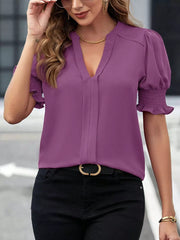 Purple blouse with notched neckline, puffed sleeves, and smocked cuffs.
