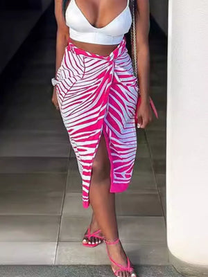 Twisted knot midi skirt with slit in rose red zebra print, featuring a tie detail and high slit.
