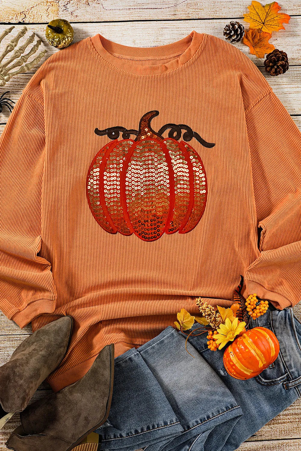 Orange corduroy sweatshirt with sequin pumpkin detail.