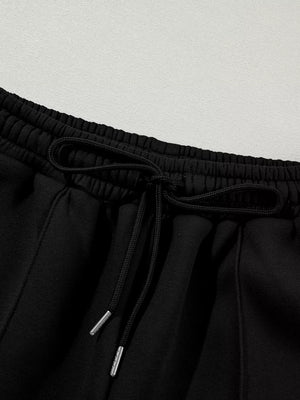 Black cotton joggers with drawstring waist and silver-tipped cords.