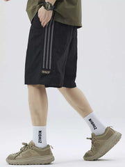 Black casual drawstring shorts with grey sporty stripes and a small patch detail.