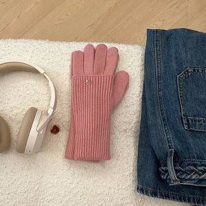 Pink ribbed knit convertible gloves with a gold button detail.