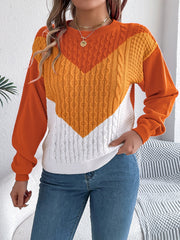 Chevron cable knit sweater in orange, yellow, and white with a contrast color block design.