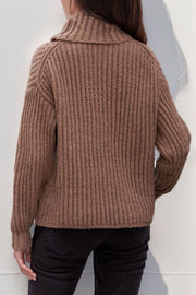 Brown chunky ribbed turtleneck sweater with relaxed fit and cuffed sleeves.