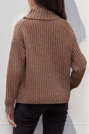 Brown chunky ribbed turtleneck sweater with relaxed fit and cuffed sleeves.