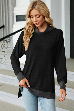 Colorblock raglan turtleneck tunic in black with dark gray accents, featuring a relaxed fit and high-low hem.