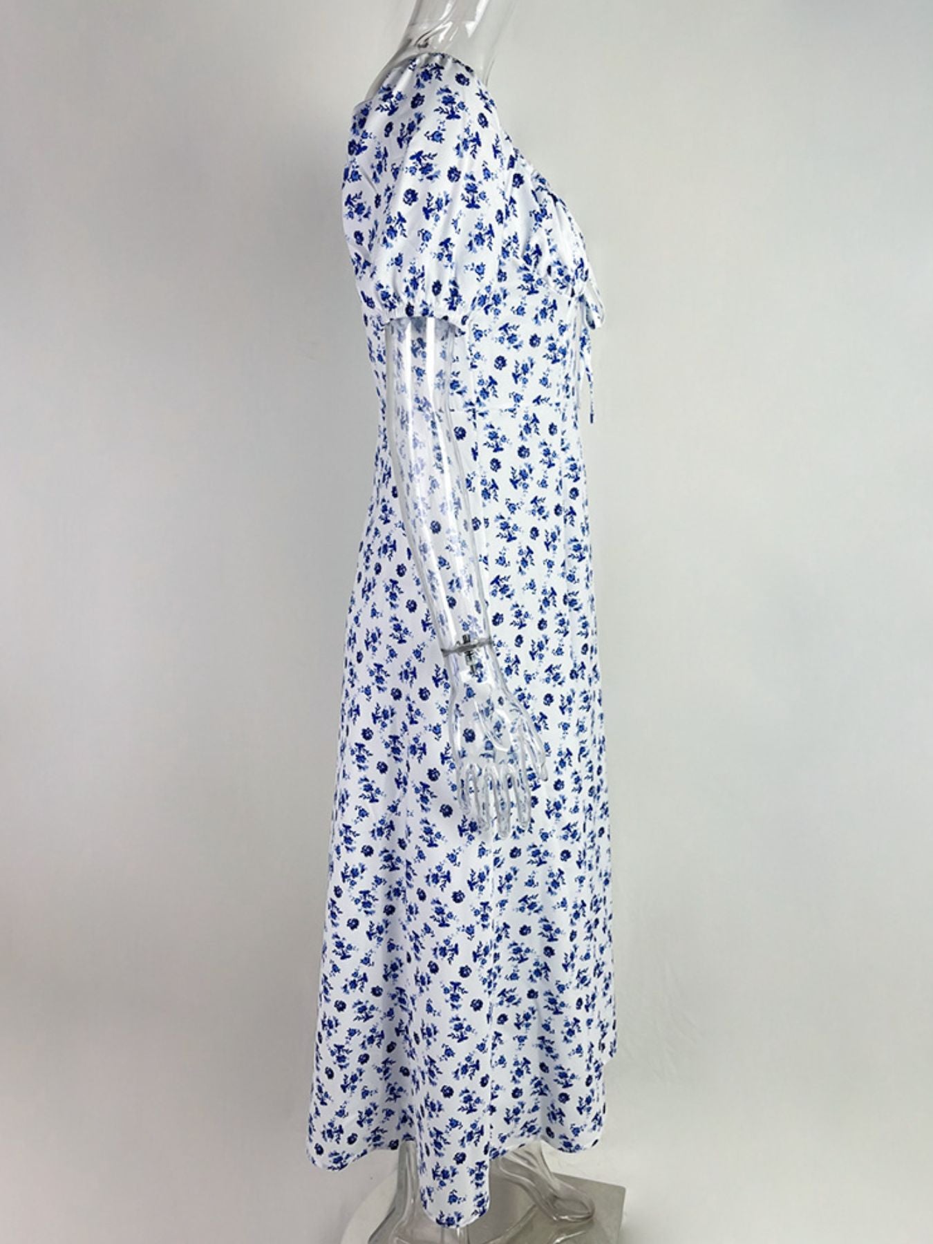White midi dress with blue floral print, tie front, and short sleeves.