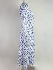 White midi dress with blue floral print, tie front, and short sleeves.
