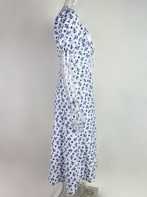White midi dress with blue floral print, tie front, and short sleeves.