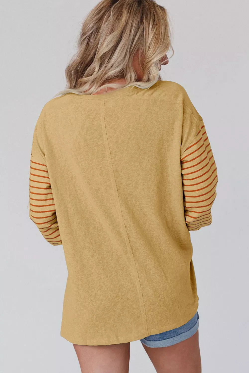 Mustard maternity shirt with bishop sleeves featuring horizontal stripes and a crew neck.