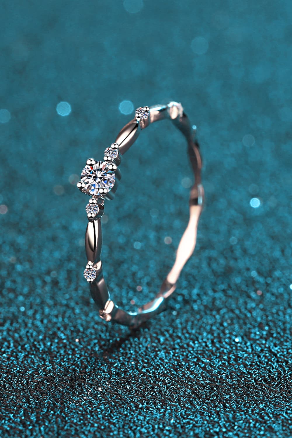 Delicate silver band ring with scalloped diamond accents and a central round-cut stone.