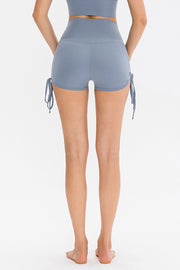 Light blue ruched-side active shorts with drawstrings and a high waist.
