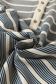 Navy and cream striped midi dress with buttoned neckline and ruffled detail.