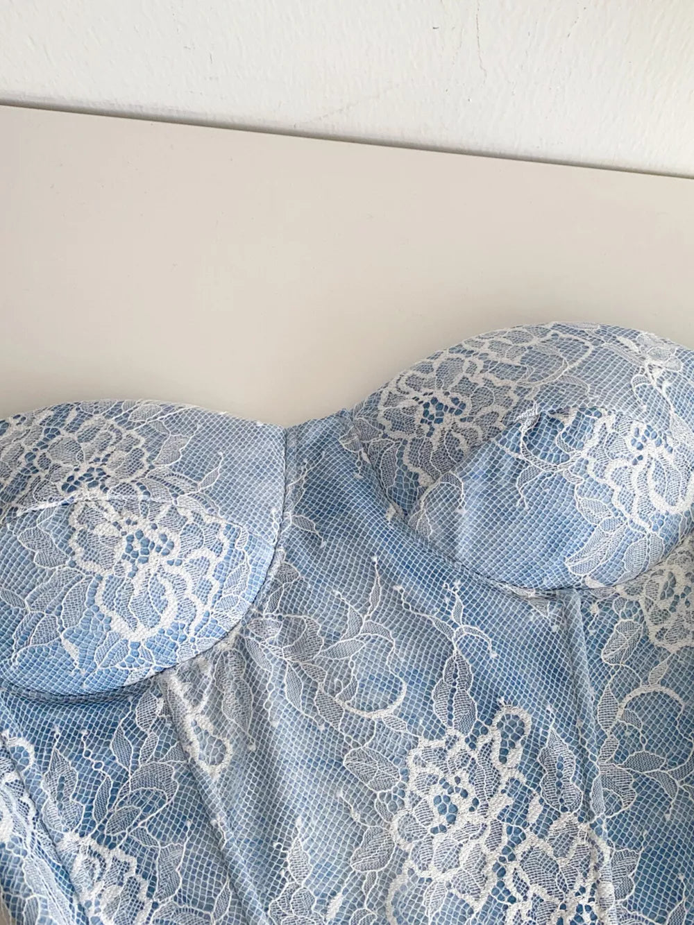Luxe floral lace tube top in blue with white lace overlay and corset detail.