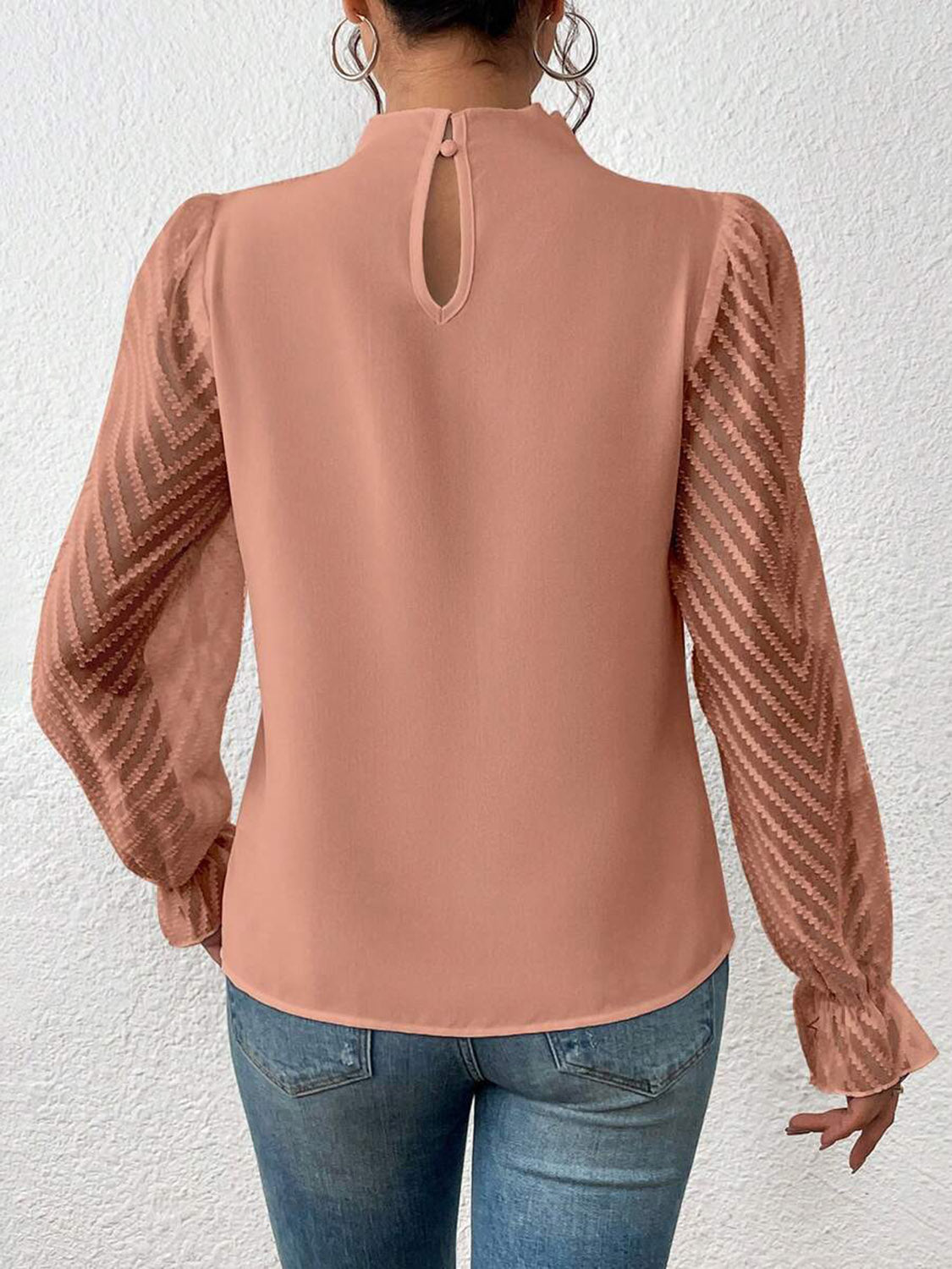 Burnt coral blouse with ruffle neck and chevron sheer sleeves.
