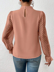 Burnt coral blouse with ruffle neck and chevron sheer sleeves.