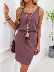 Sleeveless waffle-knit drawstring dress in pink with a tie waist and tassel detail.