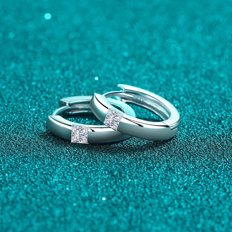 Silver hoop earrings with square moissanite stones.