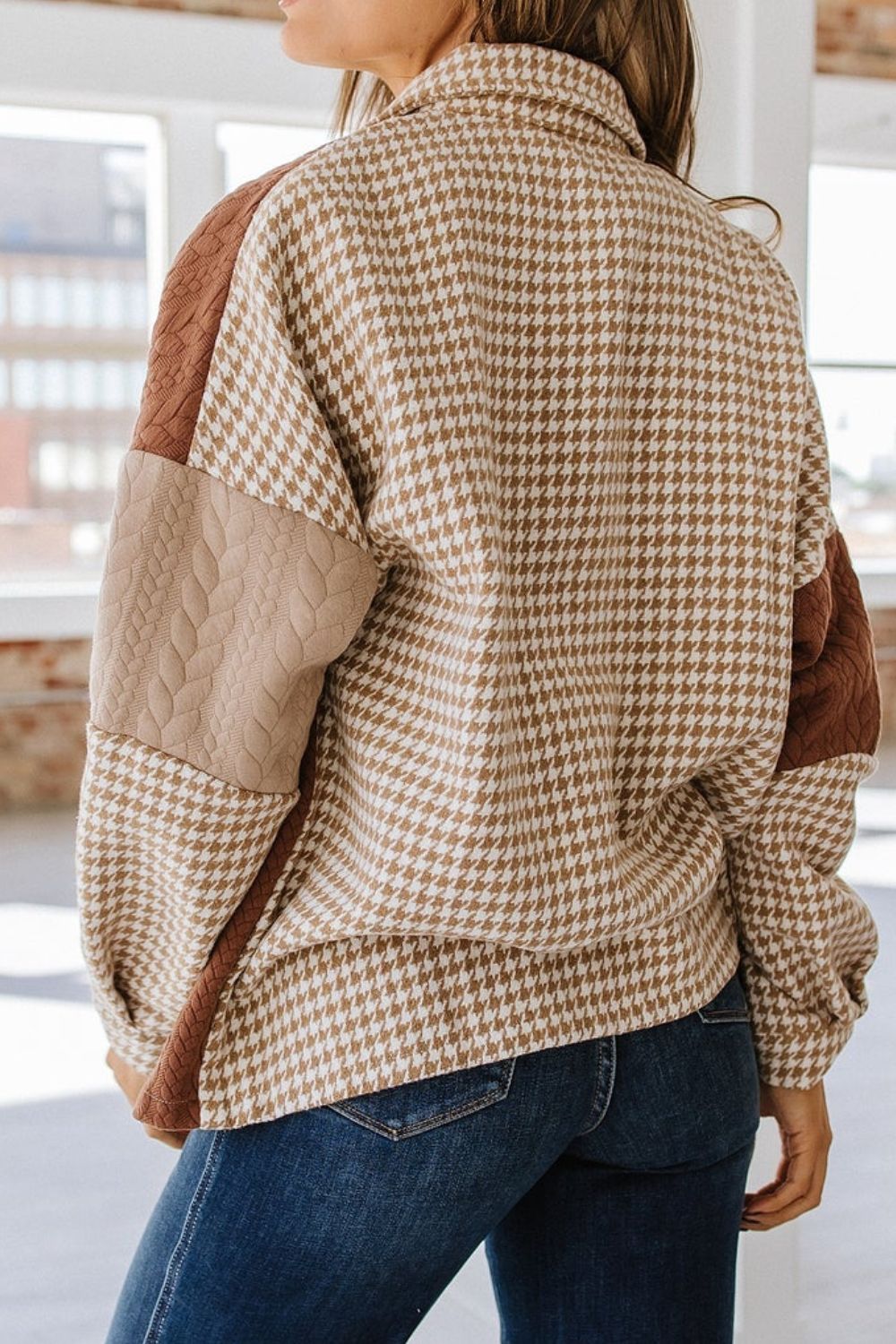 Panelled houndstooth shacket with quilted tan and brown sleeves and collared neckline.