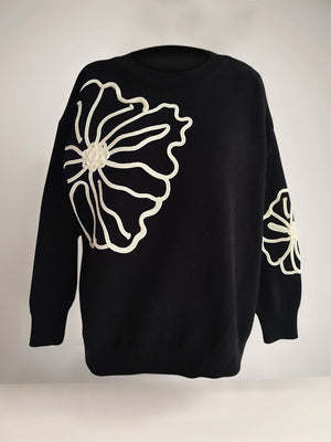Black long sleeve sweater with white floral embroidery detail on front and sleeve.