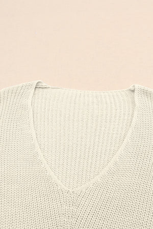 Relaxed knit V-neck pullover sweater in beige acrylic with ribbed texture.