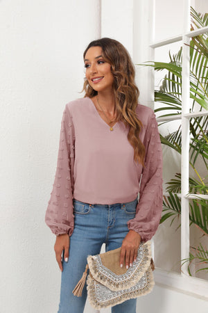 Dusty Pink V-neck blouse with pom-pom detail balloon sleeves and a relaxed fit.