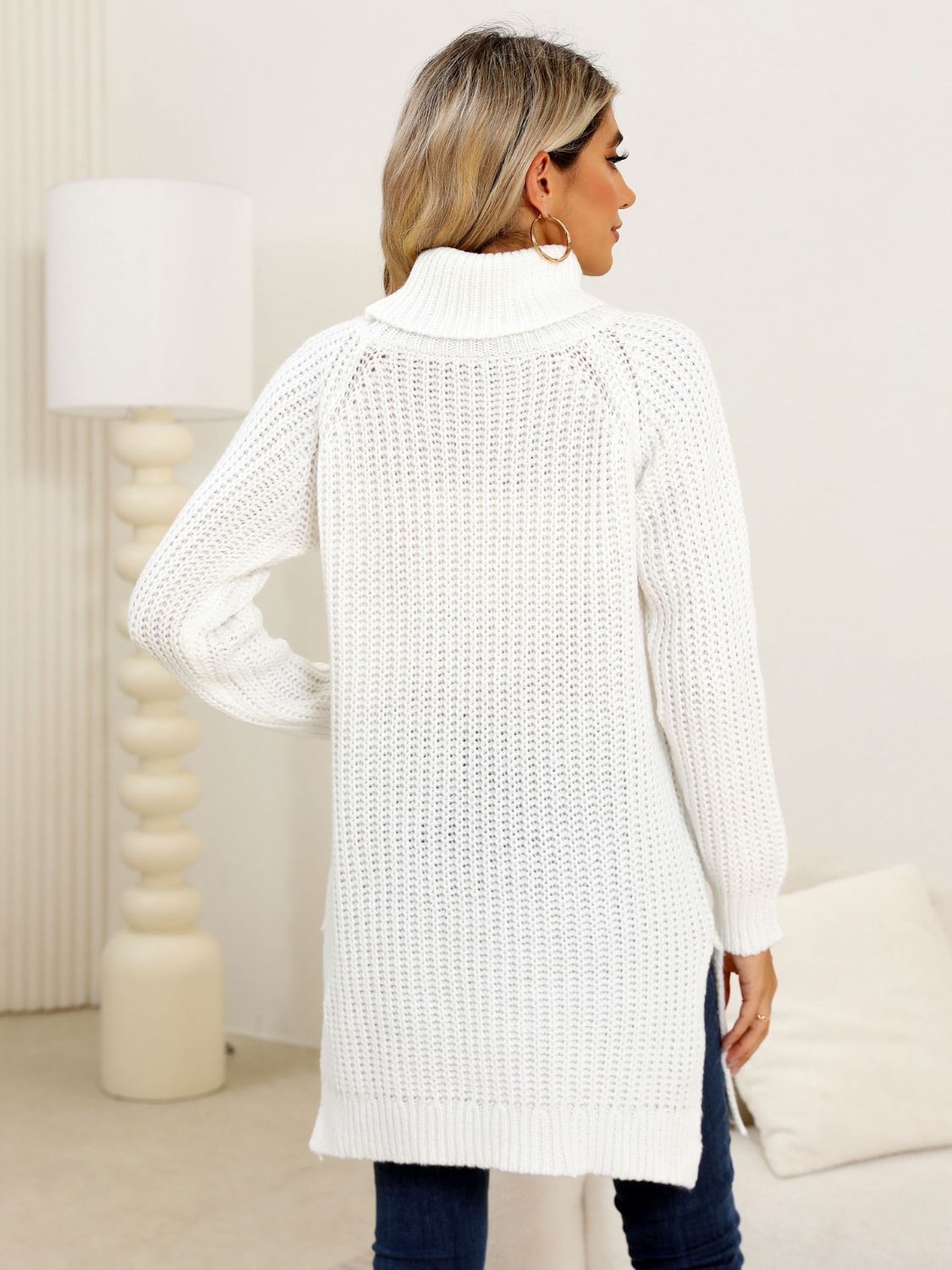 White ribbed knit turtleneck tunic with side slits.