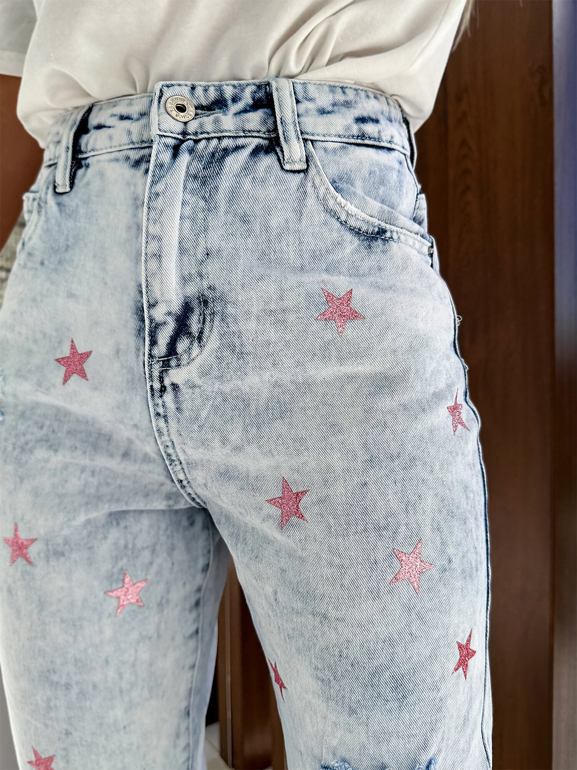 Light acid wash distressed jeans with pink glitter star embroidery