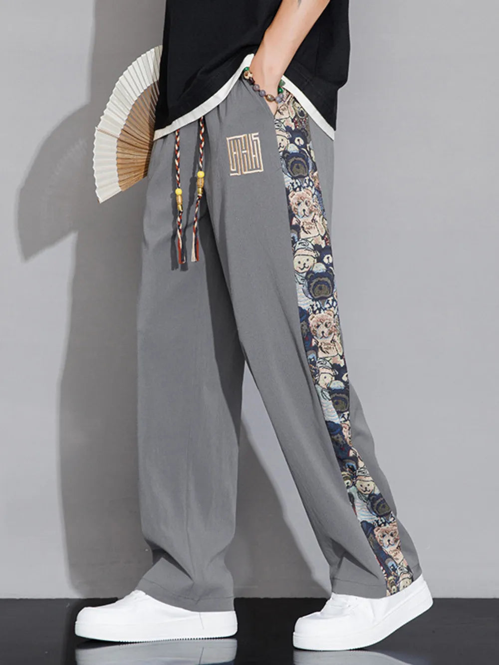 Men's light gray sweatpants with printed side stripe and drawstring.