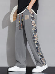 Men's light gray sweatpants with printed side stripe and drawstring.
