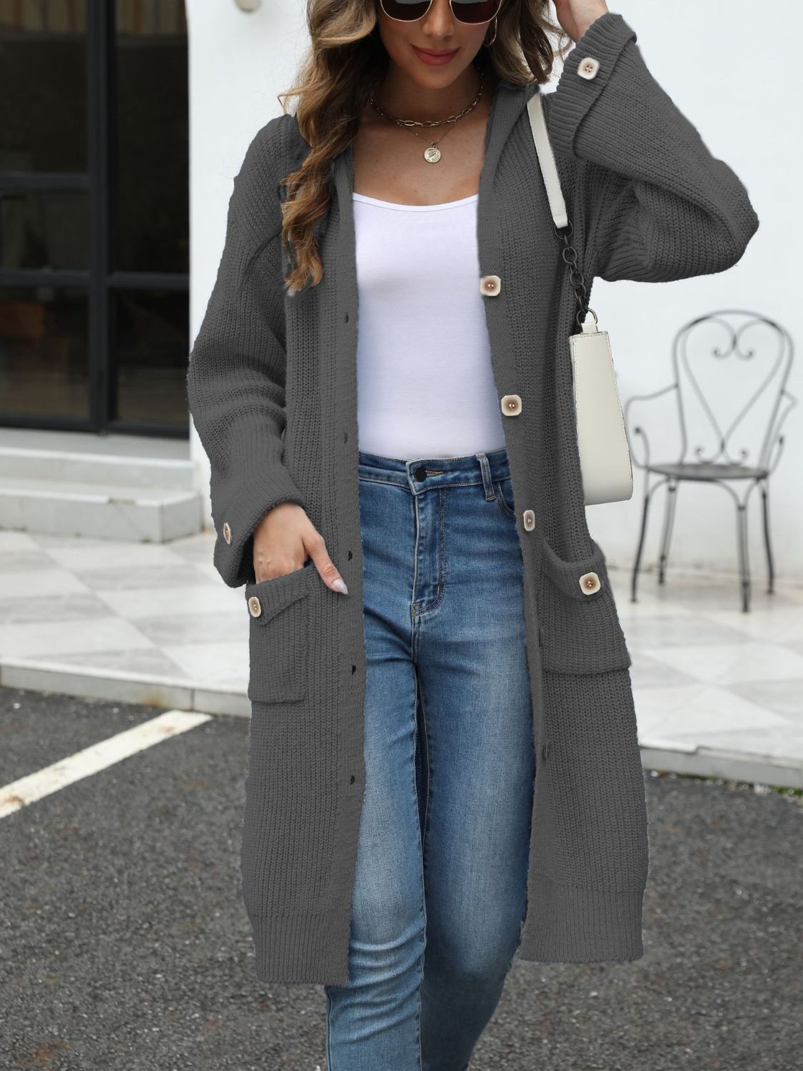 Longline gray knit cardigan with hood, buttons, and pockets.