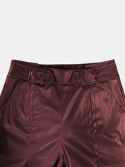 Belted faux leather palazzo trousers in burgundy with a cinched waist and buckle detail.