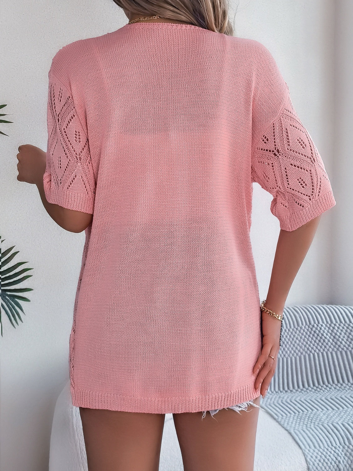 Blush pink open-knit cardigan with diamond pattern sleeves and a relaxed fit.
