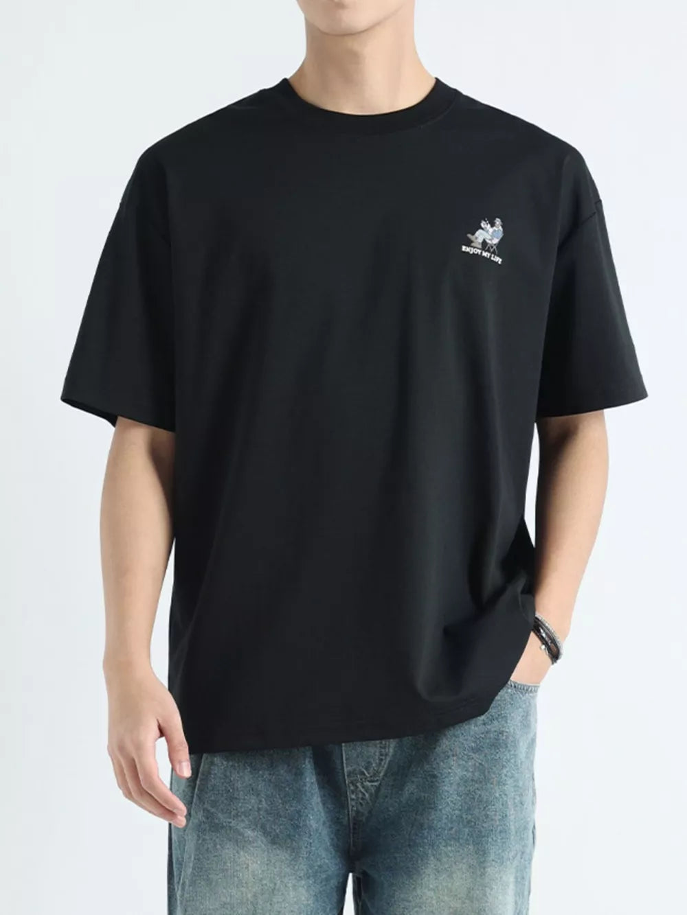 Black cotton graphic tee for men with a small chest print and relaxed fit.