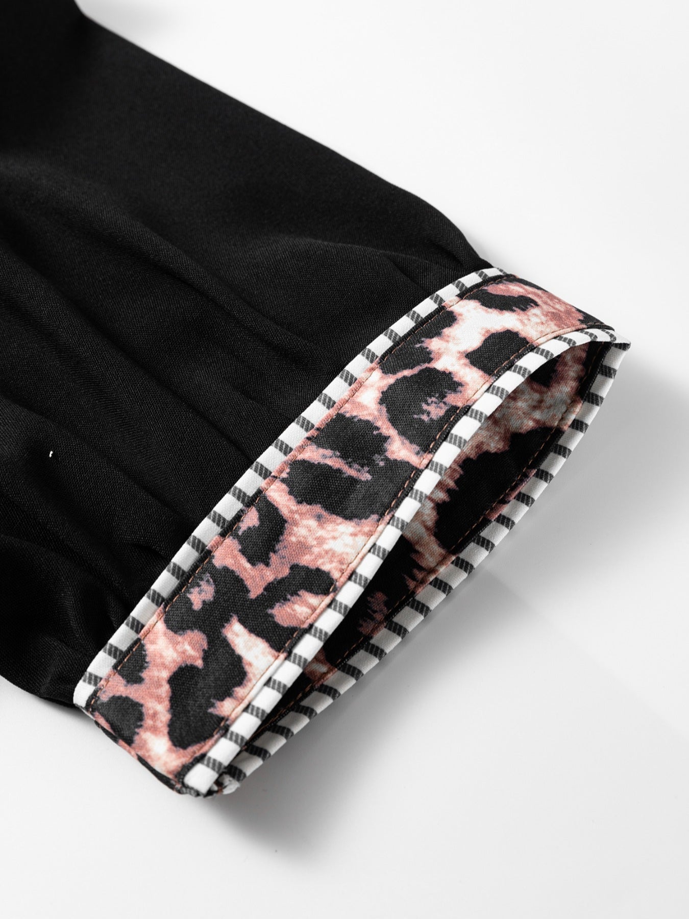 Black puff sleeve blouse with leopard print trim and striped cuff detail.